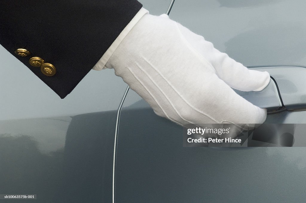 Man opening car door, close-up of gloved hand
