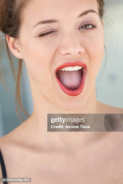 young woman winking with mouth open, close-up - human mouth stock pictures, royalty-free photos & images