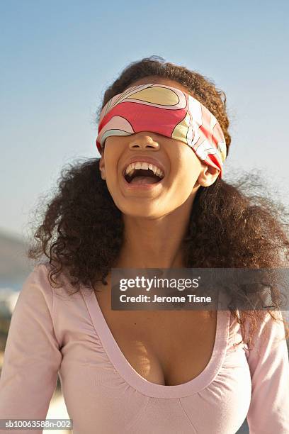 teenage girl (16-17) with blindfold, laughing - blinddoek stockfoto's en -beelden