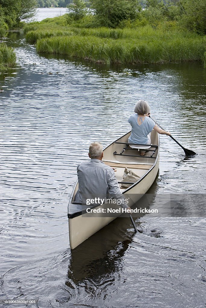 Mature couple kayaking, rear view