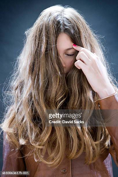 girl (12-13) moving away hair from face - thick girls stockfoto's en -beelden