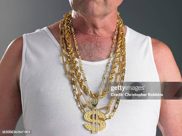 senior man wearing tank top and gold chains with dollar sign, mid section - jewelry necklace stockfoto's en -beelden