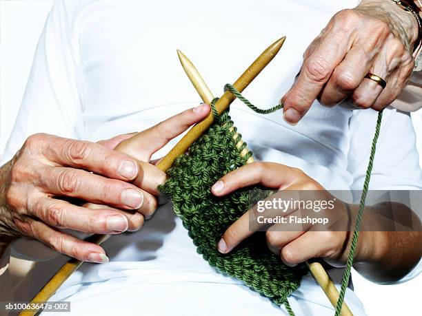 grandmother teaching granddaughter (8-9) to knit, close-up - old granny knitting stock-fotos und bilder