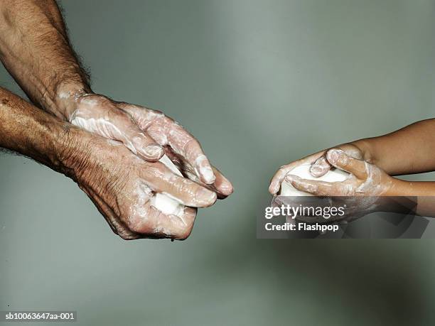 grandfather and grandson (6-7) washing hands with bar of soap, close-up - seifenstück stock-fotos und bilder