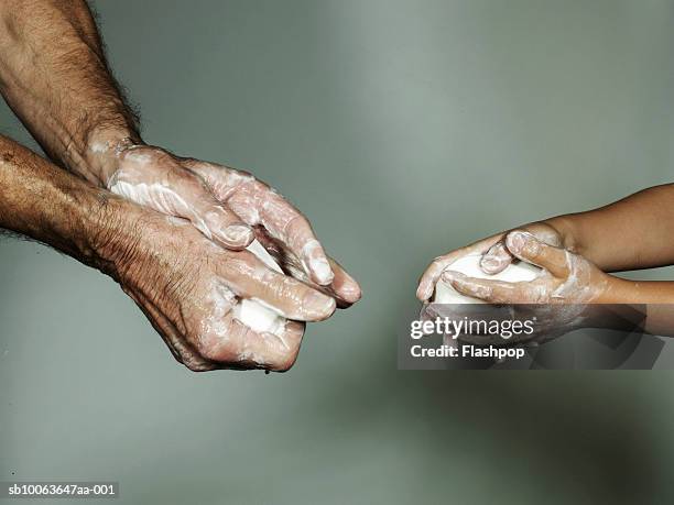 grandfather and grandson (6-7) washing hands with bar of soap, close-up - washing hands photos et images de collection