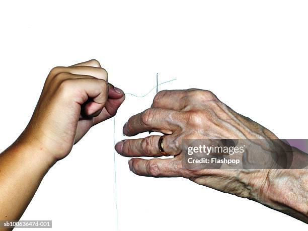 grandmother and granddaughter (8-9) threading needle, close-up - enkel object stock-fotos und bilder