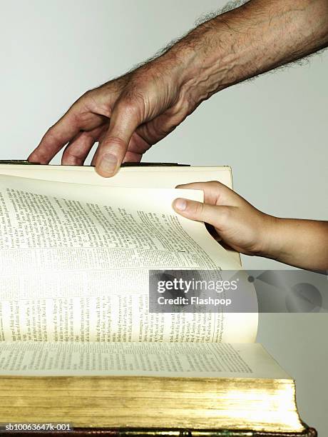 grandfather and grandson (6-7) turning book page, close-up - hand turning page stock pictures, royalty-free photos & images