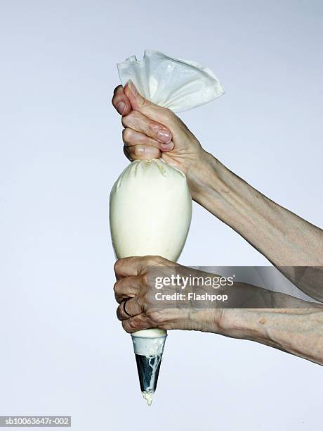 senior woman holding squeezing pipe, close-up - icing bag stock pictures, royalty-free photos & images