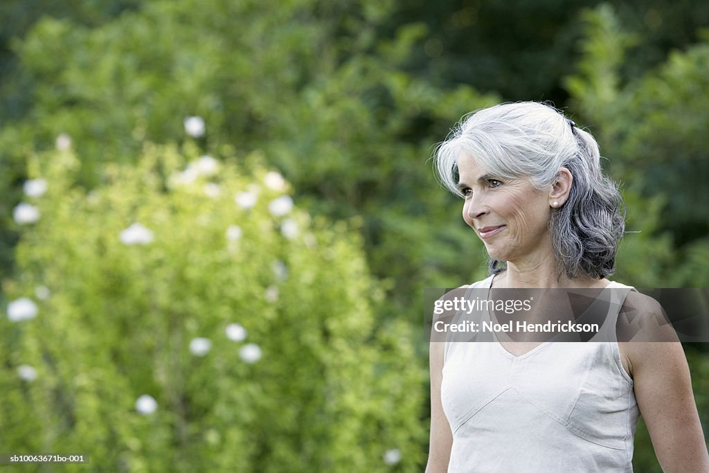 Mature woman in garden, smiling