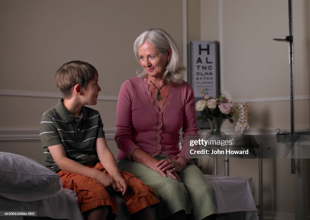 Mature female therapist sitting with boy (9-11) in practice room