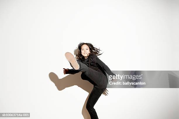 young woman kicking in mid-air - treten stock-fotos und bilder