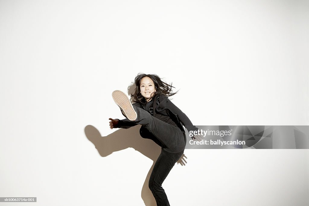 Young woman kicking in mid-air