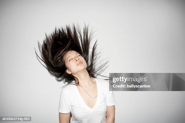 young woman tossing hair, eyes closed - sacudir el pelo fotografías e imágenes de stock