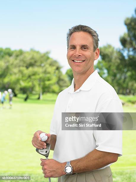golfer standing on golf course, portrait - golf short iron stock pictures, royalty-free photos & images