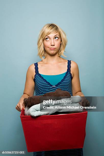 young woman holding laundry basket and looking up - laundry basket foto e immagini stock