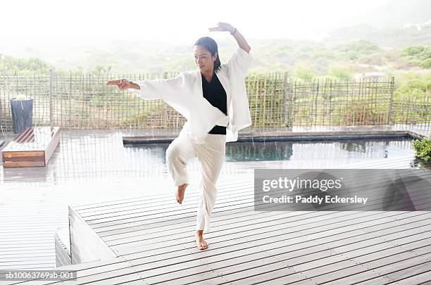 woman doing tai chi outdoors - tai chi stock-fotos und bilder