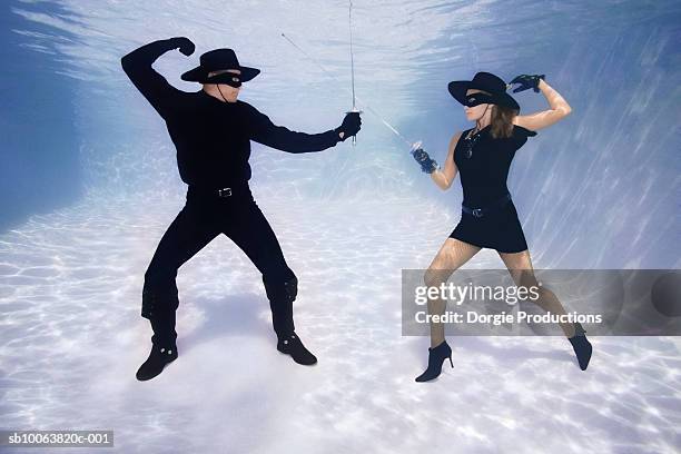 mature couple fencing with swords underwater - mask confrontation stock pictures, royalty-free photos & images