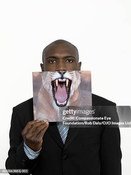 young businessman holding picture of lion's mouth, portrait - animal body part stock pictures, royalty-free photos & images