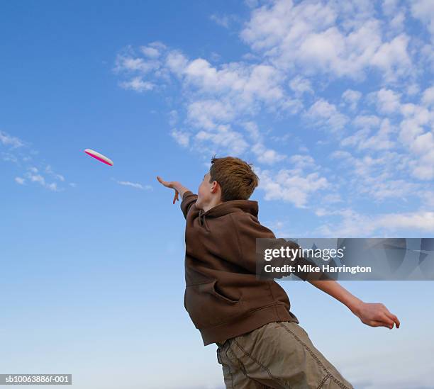 boy (14-15) throwing frisbee, rear view - throwing frisbee stock pictures, royalty-free photos & images