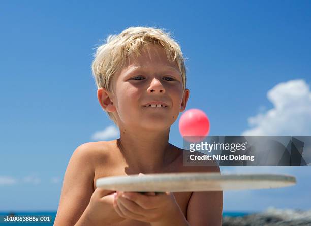 boy (8-9 years) playing bat and ball on beach - 8 9 years stock-fotos und bilder