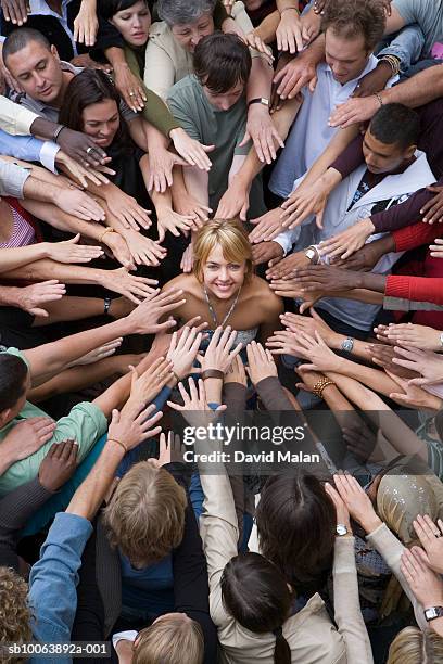 elevated view of crowd surrounding woman, reaching toward her - surrounding ストックフォトと画像