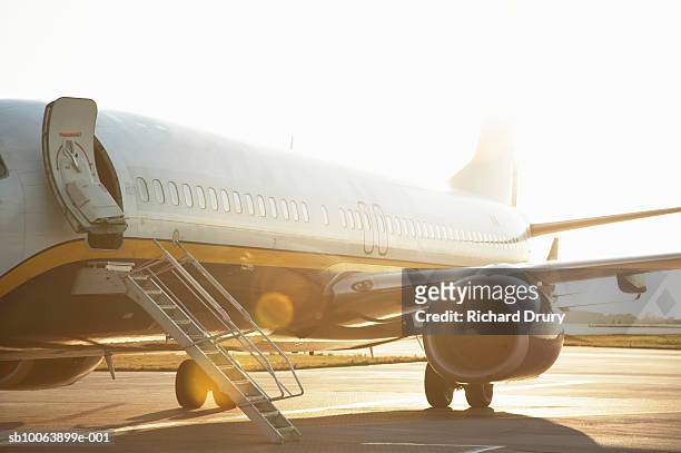 airpane on runway at sunset (lens flare) - fuselagem - fotografias e filmes do acervo