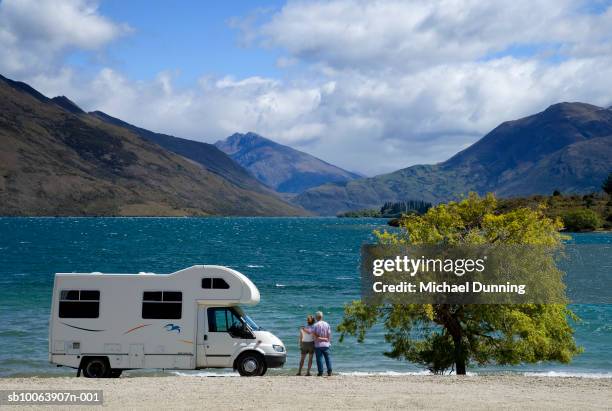 couple outside camper looking at lake - rv camping stock pictures, royalty-free photos & images