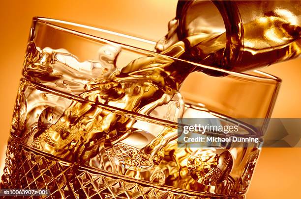 whiskey pouring into glass, close-up - spirituosen stock-fotos und bilder