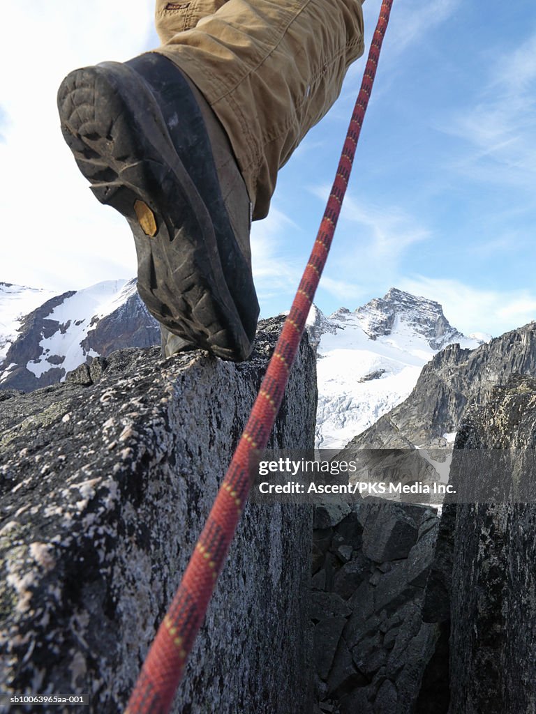 Mountaineer climbing rock with rope, low section