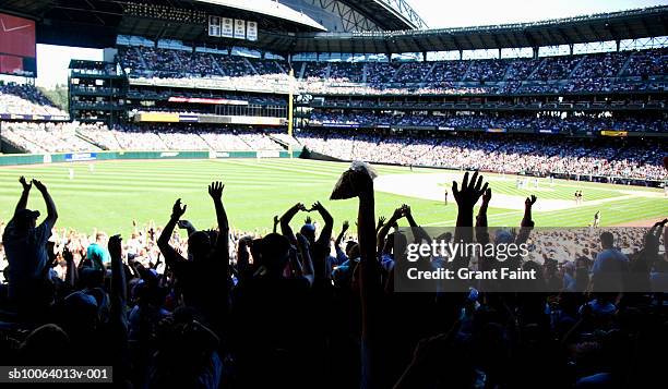 crowd at stadium cheering during baseball match - silhouette sports crowd stock pictures, royalty-free photos & images