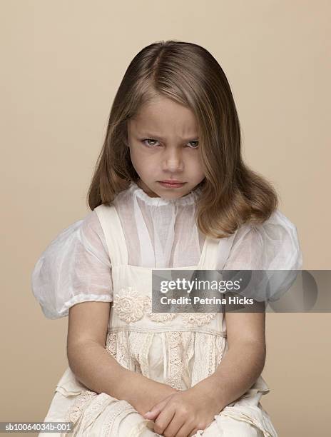 portrait of girl (4-5) frowning, sitting in studio - frowning stock pictures, royalty-free photos & images