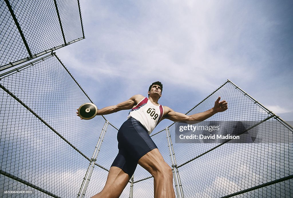 Man preparing to throw discus at track, low angle view