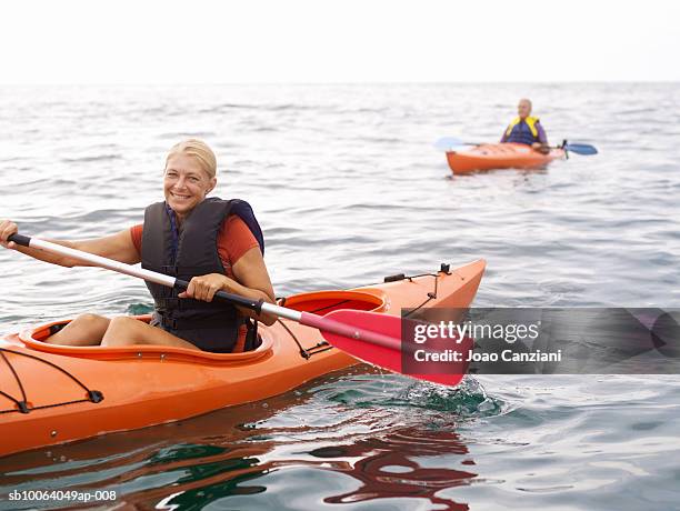 woman kayaking, man in background - kayak fotografías e imágenes de stock