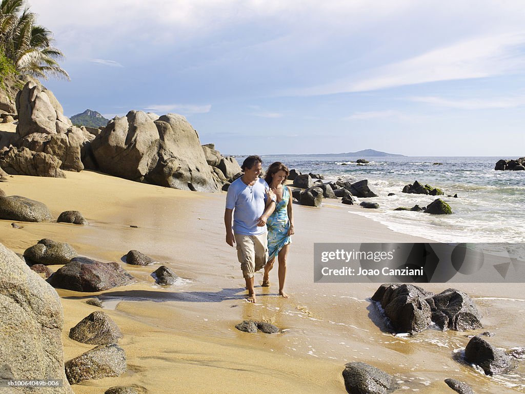 Couple walking on rocky beach