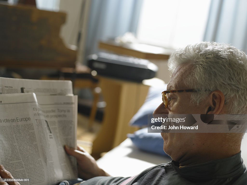 Mature man reading newspaper, close up