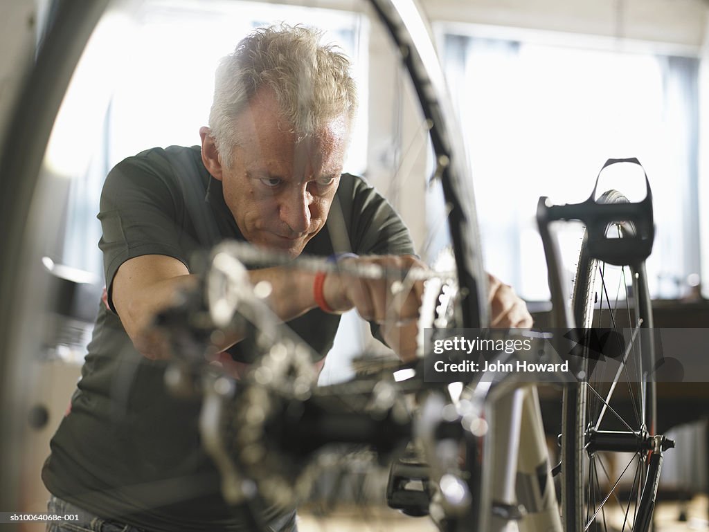 Mature man adjusting bicycle chain