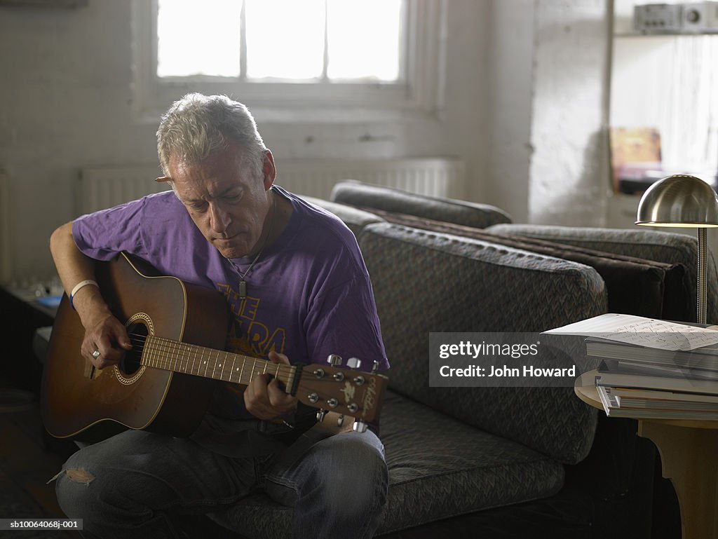 Mature man playing acoustic guitar