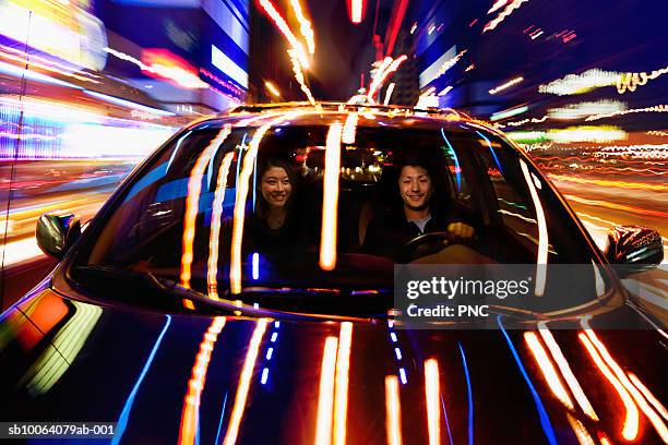 couple in car at night, lights reflected on bonnet - asian couple car stock pictures, royalty-free photos & images