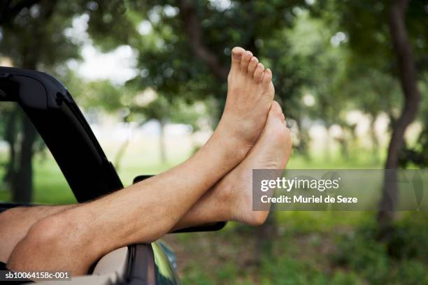 man's legs coming out from side of cabriolet - barefoot stock pictures, royalty-free photos & images