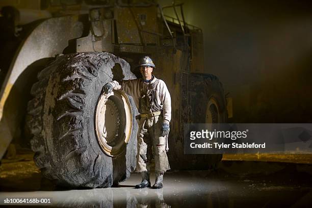 mining worker standing beside tyre in marble quarry - miner stock pictures, royalty-free photos & images