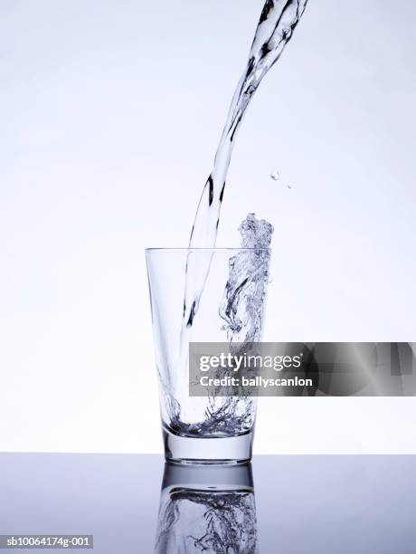 water being poured into glass, studio shot - drinking glass of water stock pictures, royalty-free photos & images