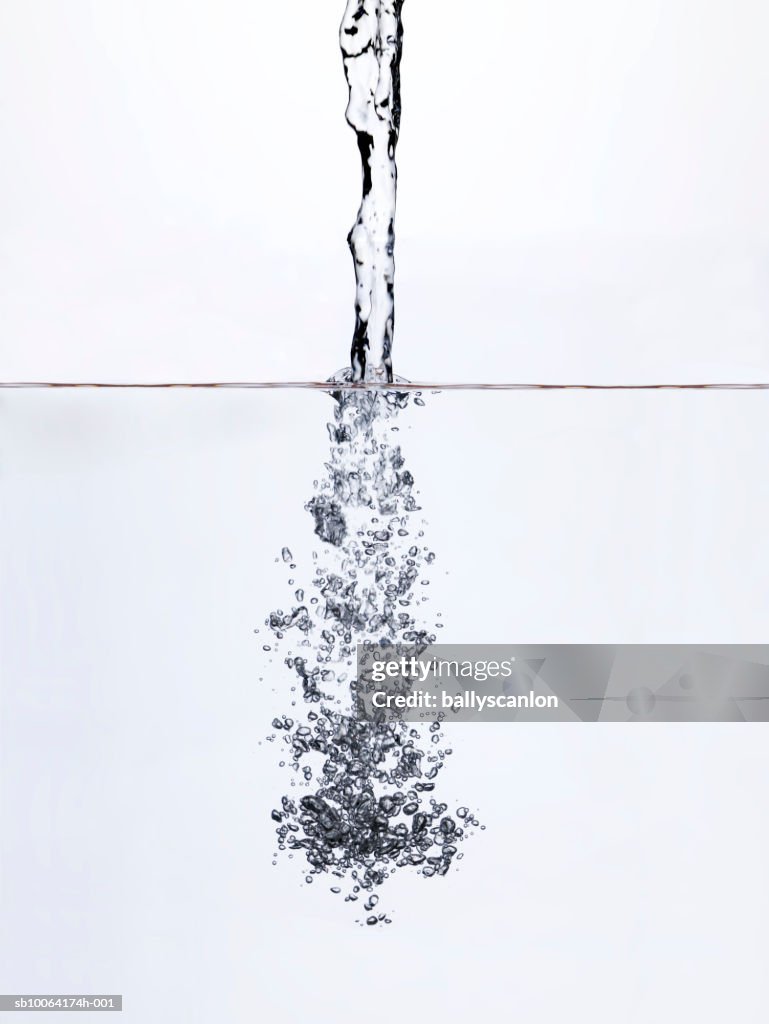 Water being poured into water, surface view, studio shot