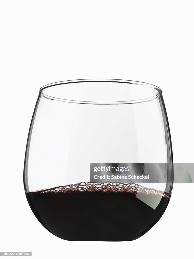 Stemless glass with red wine on white background
