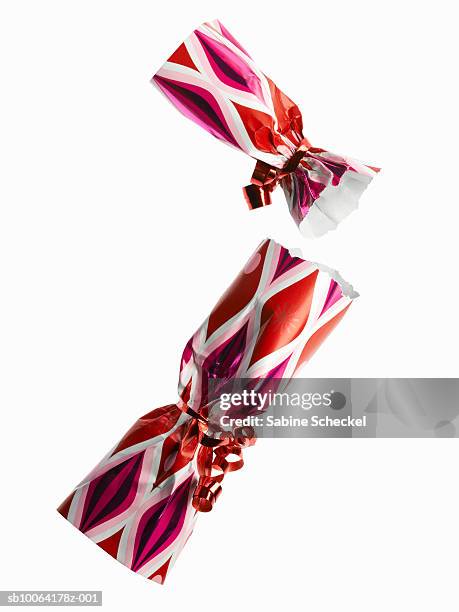 two red and pink party cracker on white background - christmas crackers stock pictures, royalty-free photos & images