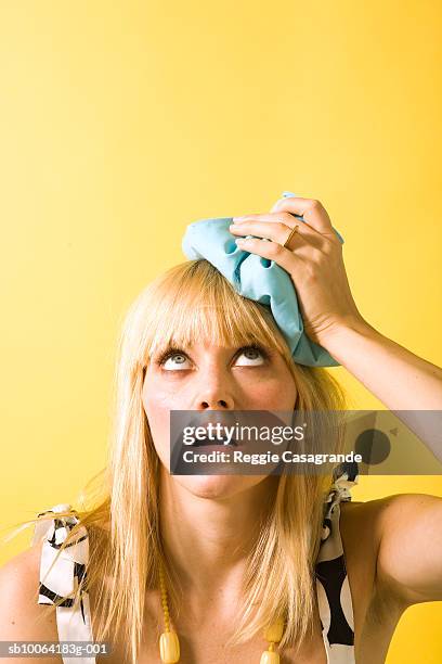 young woman with icepack on head, close-up - ijszak stockfoto's en -beelden