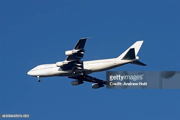 boeing 747 jumbo jet against blue sky - 747 stock-fotos und bilder