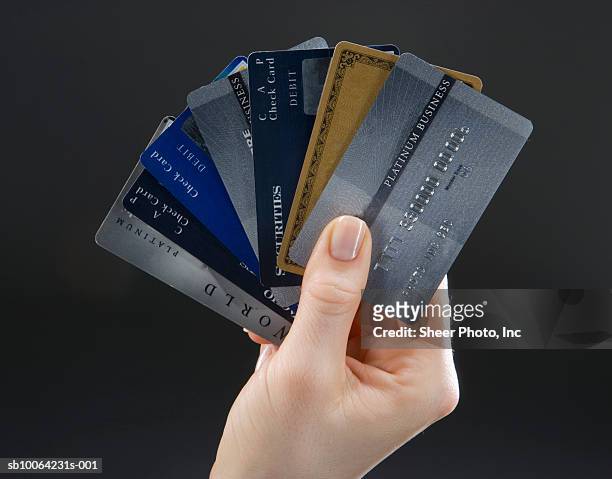 woman holding set of fanned-out credit cards, close-up of hand - abrir en abanico fotografías e imágenes de stock