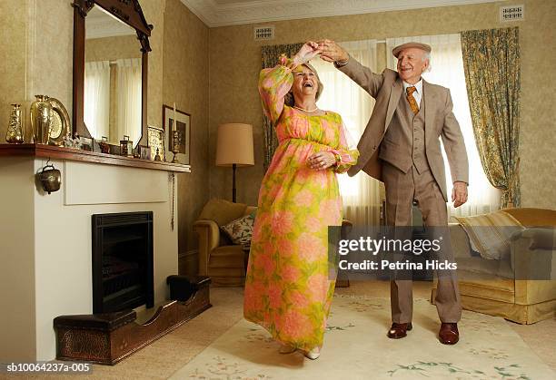 senior couple dancing in living room - couple dancing at home stockfoto's en -beelden