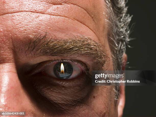 flame projected in eye of senior man, close-up - evil stock pictures, royalty-free photos & images