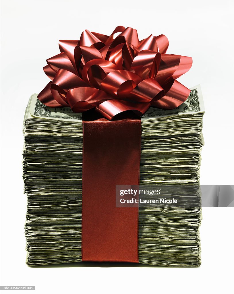 Stack of dollars wrapped in red bow